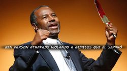 Ben Carson, vestido con traje y corbata, emocionado y sonriente mientras sostiene una espada roja en el escenario. El fondo es de color amarillo. Interner Link zu einem Artikel auf dieser Website.