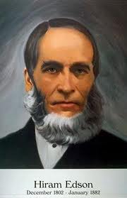 Retrato de un hombre maduro con barba poblada blanca y vestimenta formal del siglo XIX. Los detalles incluyen un traje oscuro, chaleco y corbata, y mira serenamente hacia el espectador. Hay texto bajo la imagen que indica su nombre, Hiram Edson, junto con las fechas diciembre 1802 - enero 1882.