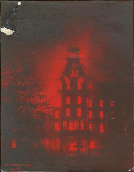 Imagen monocrom&aacute;tica roja de un edificio de estilo victoriano iluminado misteriosamente en la noche, proyectando una atm&oacute;sfera et&eacute;rea similar a la luz de una nebulosa astron&oacute;mica, sin referencias a la Mazzaroth.
