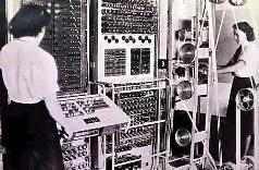 Dos mujeres trabajando meticulosamente en un gran panel de control con numerosos interruptores y cables para el procesamiento de datos astron&oacute;micos y c&aacute;lculos relacionados con la Mazzaroth.