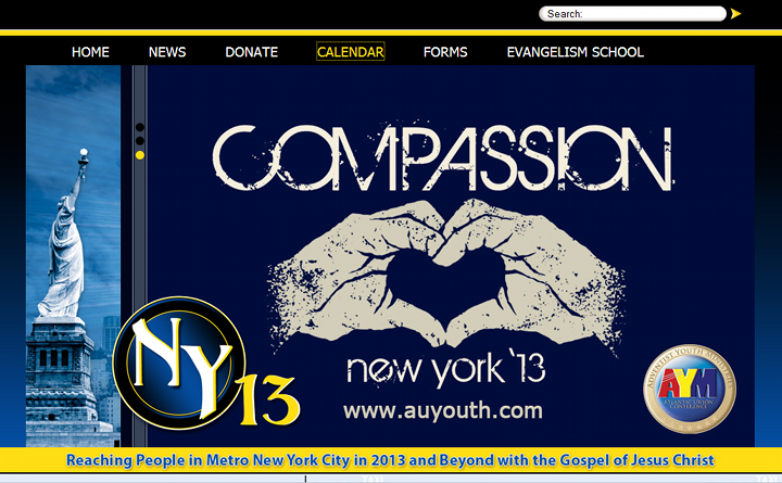Captura de pantalla de un sitio web con un dise&ntilde;o que incluye la Estatua de la Libertad en el extremo izquierdo, sobre un fondo azul oscuro. El centro muestra la palabra "COMPASSION" en letras grandes y blancas sobre dos manos formando un coraz&oacute;n con un mapa estrellado dentro, simbolizando la Mazzaroth. En la parte inferior, textos promocionales sobre eventos en Nueva York en 2013 con enlaces a su p&aacute;gina web.