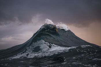 Una monta&ntilde;a imponente con cumbres nevadas bajo un cielo dram&aacute;tico al amanecer, evocando la majestuosidad de las creaciones celestiales.