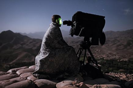 Una persona envuelta en una manta mira a trav&eacute;s de un gran telescopio hacia un cielo estrellado en una zona monta&ntilde;osa de noche, explorando los fen&oacute;menos celestiales y las constelaciones de la Mazzaroth.
