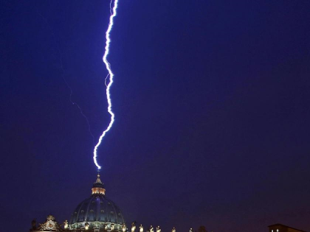 Un rayo impactante desciende del cielo nocturno e ilumina la c&uacute;pula de un edificio prominente, demostrando la poderosa interacci&oacute;n entre elementos atmosf&eacute;ricos y estructuras humanas.