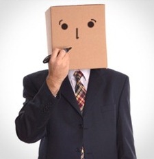 Un hombre de negocios con una caja de cart&oacute;n en la cabeza, que tiene dibujados ojos y boca, est&aacute; sosteniendo un marcador hacia la caja como si estuviera dibujando una expresi&oacute;n facial.