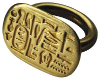 Anillo dorado con un escarabajo grabado en la parte superior, rodeado de jerogl&iacute;ficos egipcios, que simboliza temas relacionados con la Mazzaroth sin especificar cu&aacute;les.