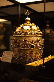 Un intrincado esfera dorada representando las constelaciones del Mazzaroth en un contexto hist&oacute;rico y cultural, exhibido bajo una luz tenue.