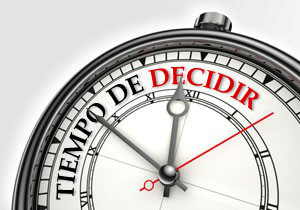 Reloj anal&oacute;gico cl&aacute;sico mostrando la frase "Tiempo de Decidir" en su esfera, con las manecillas marcando aproximadamente las diez y diez.