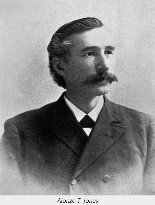 Fotograf&iacute;a en blanco y negro de un hombre de finales del siglo XIX, Alonzo T. Jones, con un elegante bigote y cabello peinado hacia atr&aacute;s. Luce un traje oscuro con corbata y cazadora. Su mirada seria y postura formal reflejan la norma estil&iacute;stica de su &eacute;poca.